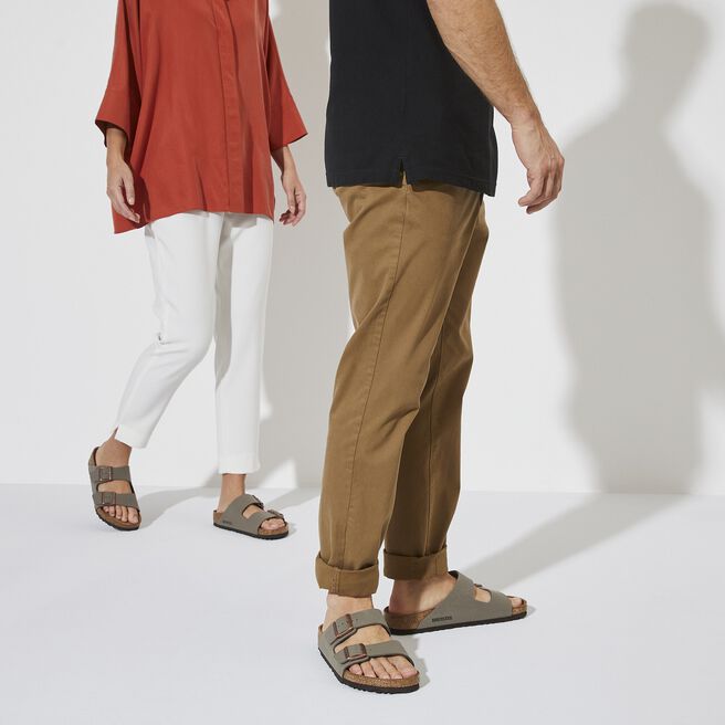 Two people wearing Birkenstock Arizona sandals in stone color with casual outfits