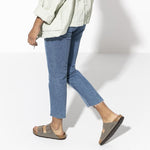 Person wearing Birkenstock Arizona sandals in stone color with jeans