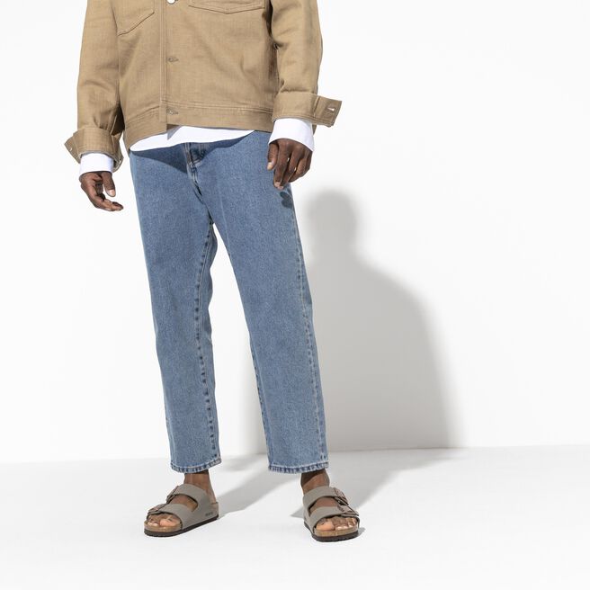 Birkenstock Arizona sandals in stone color worn with jeans and beige jacket