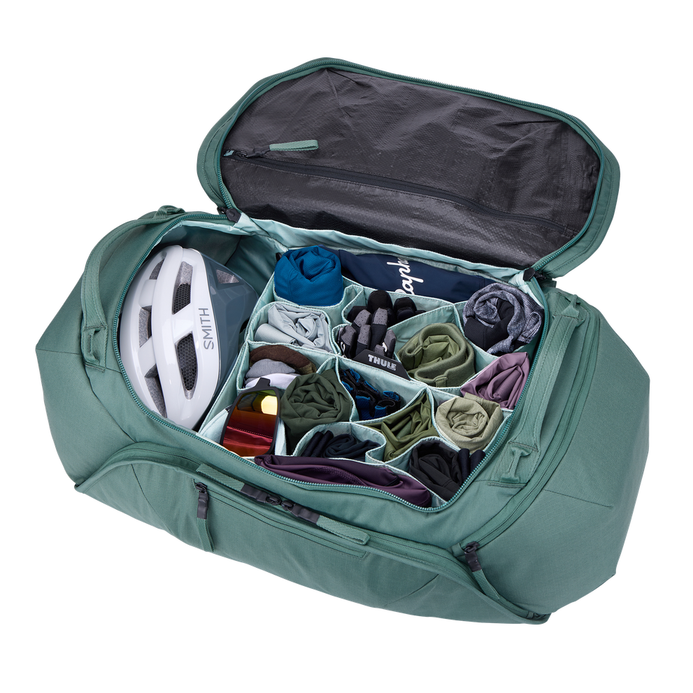 Thule Roundtrip bike duffel bag open showing organized compartments with helmet and clothes