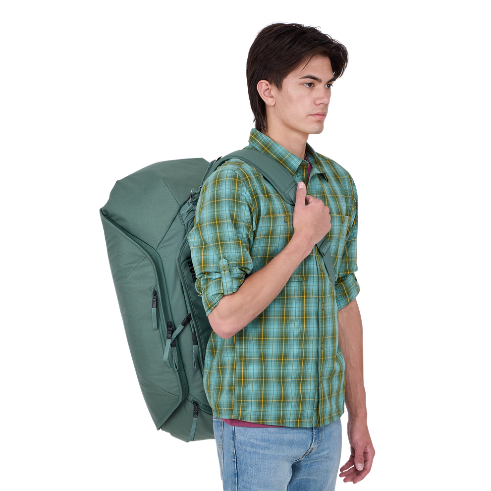 Man wearing Thule Roundtrip Bike Duffel 55L in hazy green color