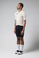 Male model wearing white Gobik Phantom cycling jersey with black shorts on gray background