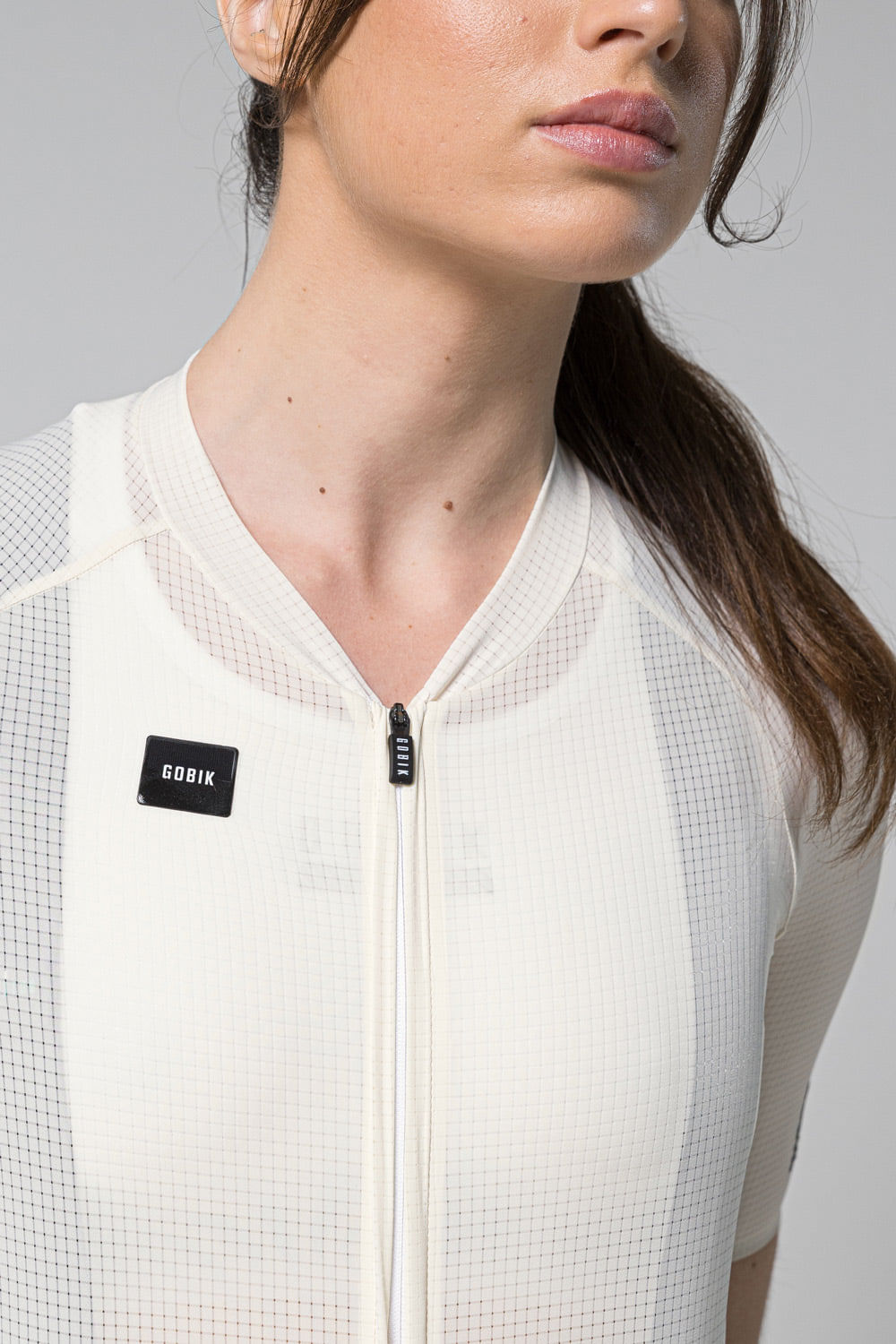 Woman wearing white Gobik Phantom Jersey with zip front and mesh panels