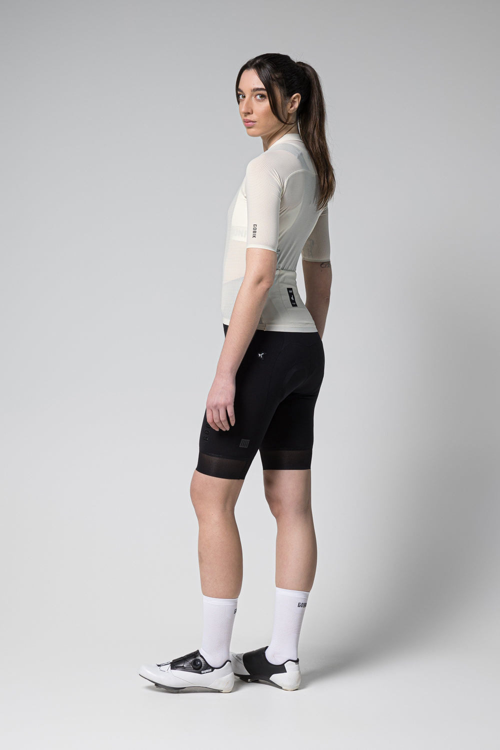 Woman wearing Gobik Phantom Jersey in tofu color with black cycling shorts