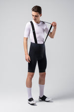 Man wearing black Gobik X bib shorts with suspenders and white cycling jersey