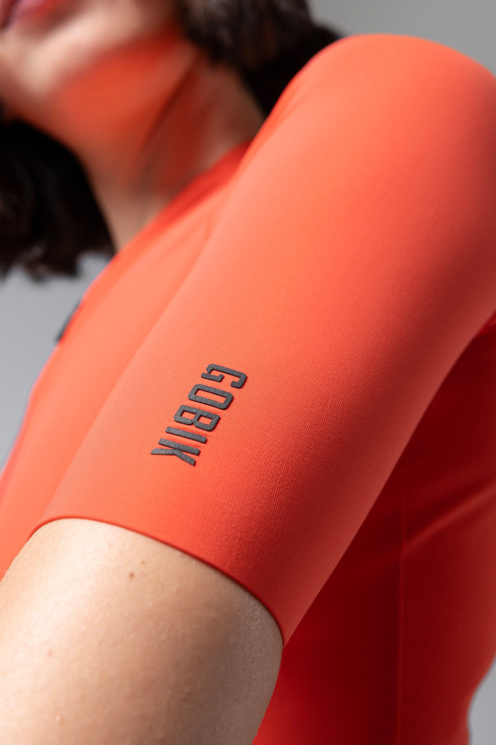 GOBIK CX Solid cycling jersey in coral orange worn by model