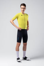 Male cyclist wearing bright yellow Gobik CX jersey with black cycling shorts