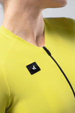 Close-up of yellow Gobik cycling jersey with black logo patch and zipper detail
