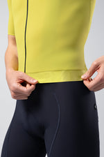 Model wearing bright yellow Gobik CX cycling jersey with navy shorts