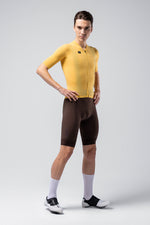 Male model wearing bright yellow Gobik Phantom cycling jersey with brown shorts