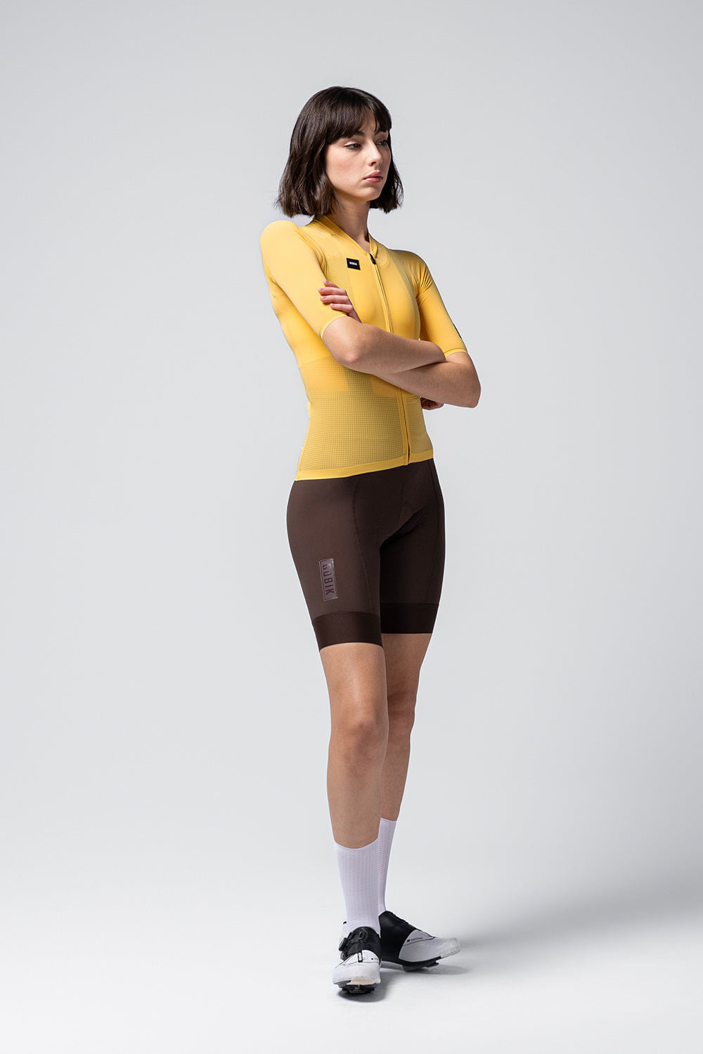 Model wearing yellow Gobik Phantom cycling jersey with dark shorts on white background