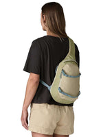 Person wearing Patagonia Atom Sling 8L in weathered stone color across shoulder