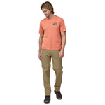 Man wearing Patagonia Quandary convertible pants in classic tan with orange t-shirt