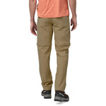 Man wearing Patagonia Quandary convertible pants in classic tan, rear view showing zip-off design