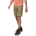 Man wearing olive green Patagonia Quandary convertible shorts with hiking boots