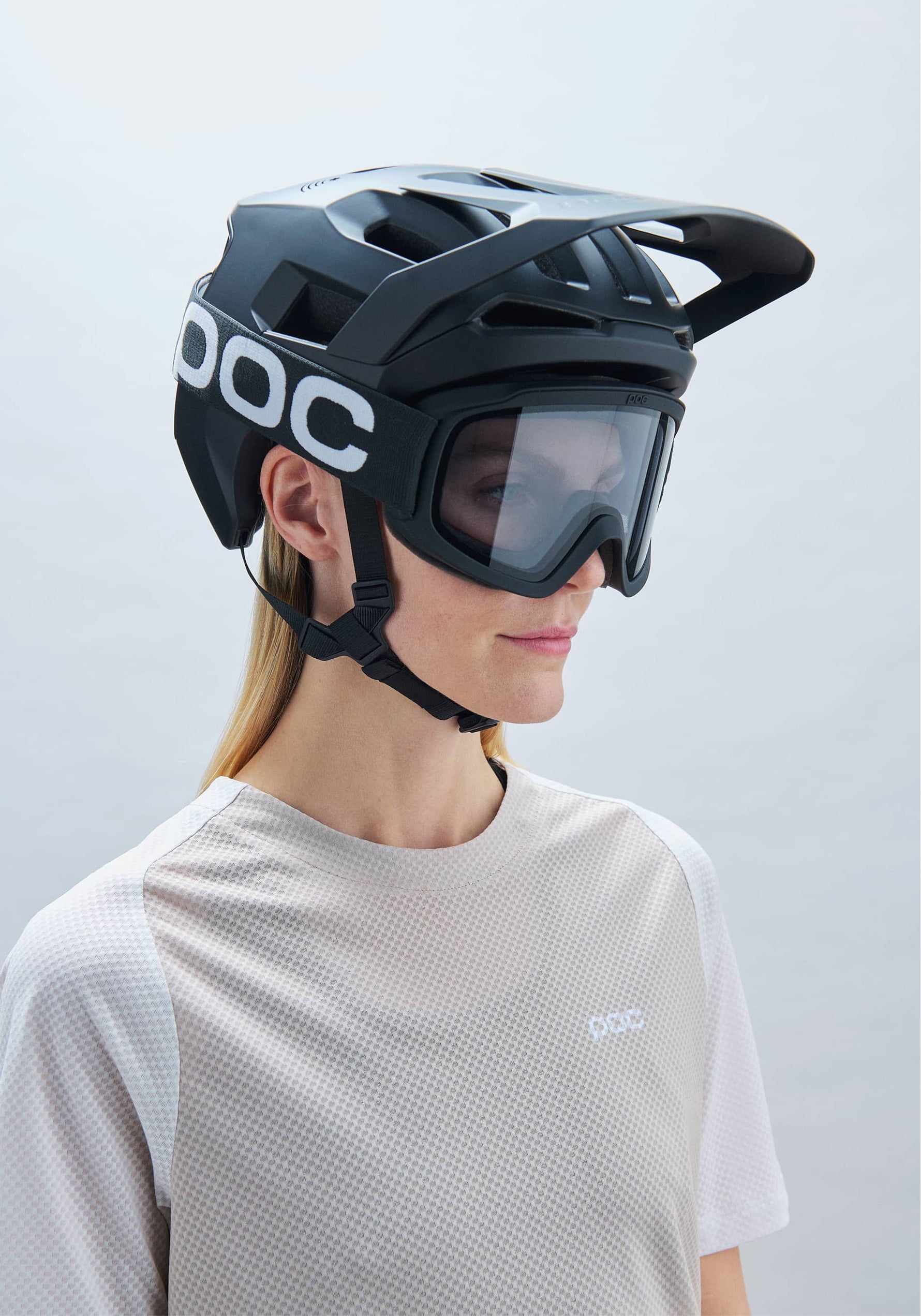 Woman wearing POC Kortal mountain bike helmet in matte black with integrated goggles