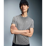 Man wearing gray heathered On Core-T shirt with arms crossed against studio background