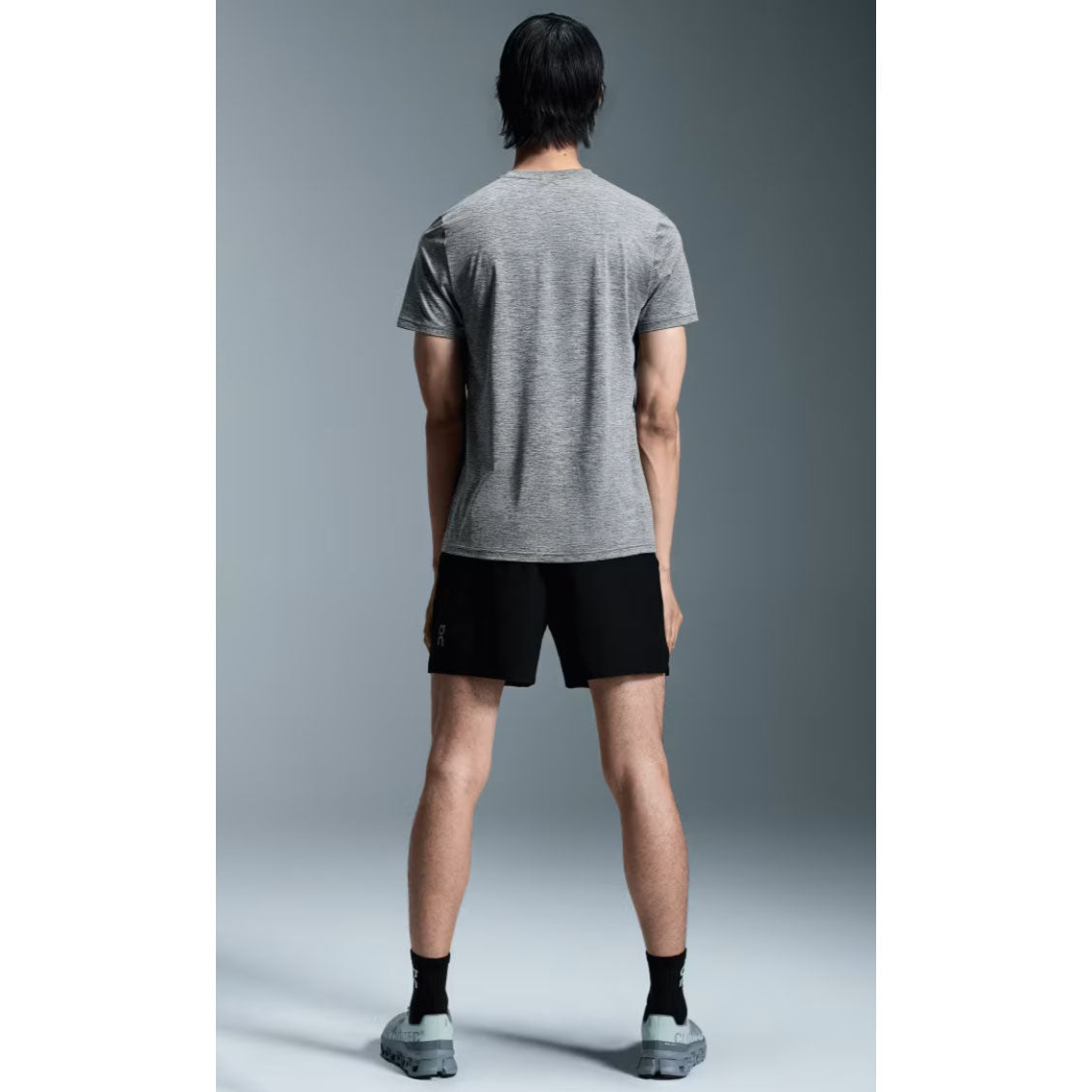 Back view of man wearing gray On Core-T shirt and black shorts