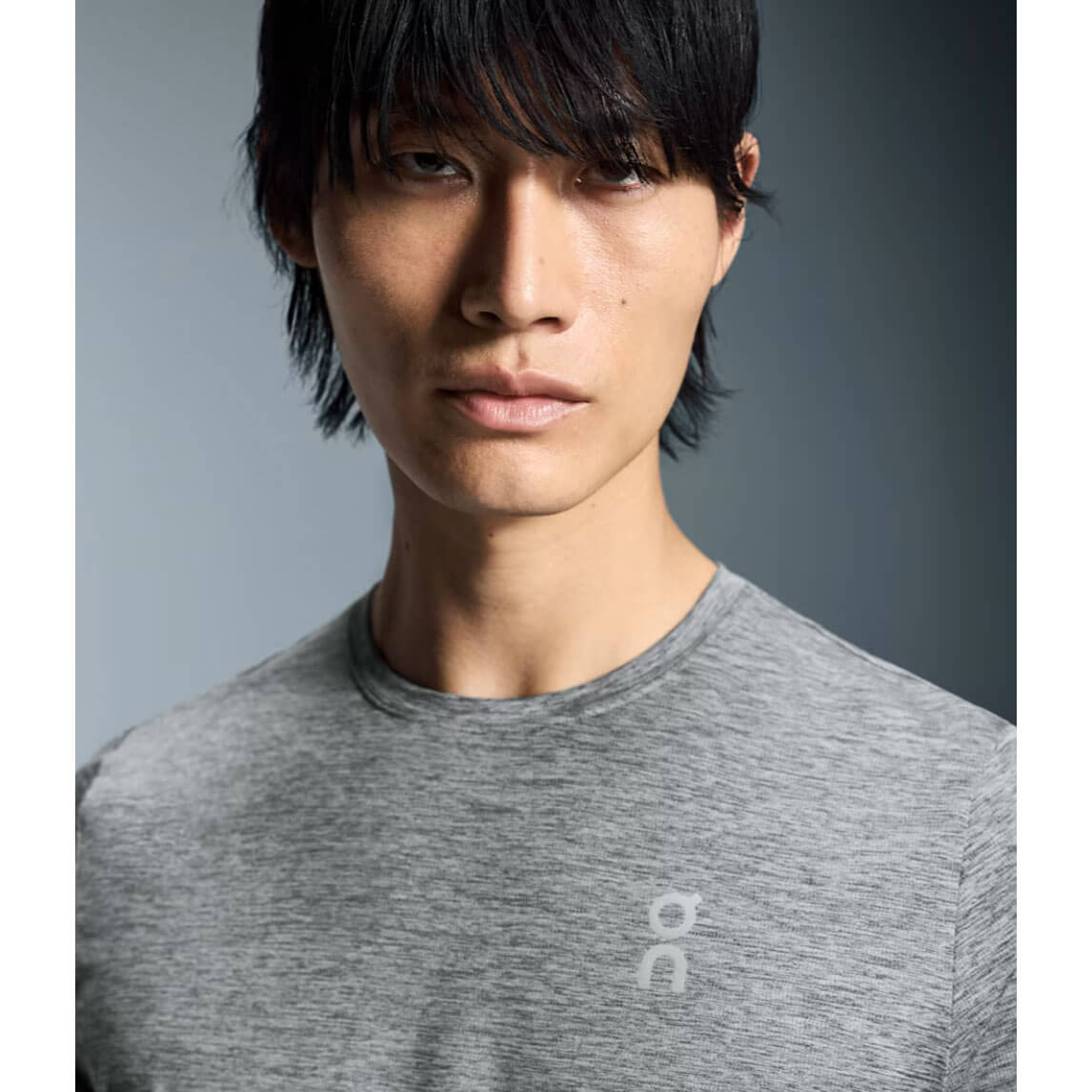 Man wearing gray heathered On Core-T athletic shirt in studio portrait