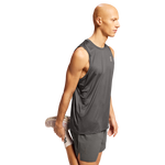 Man wearing dark gray On Core Tank sleeveless athletic shirt on white background