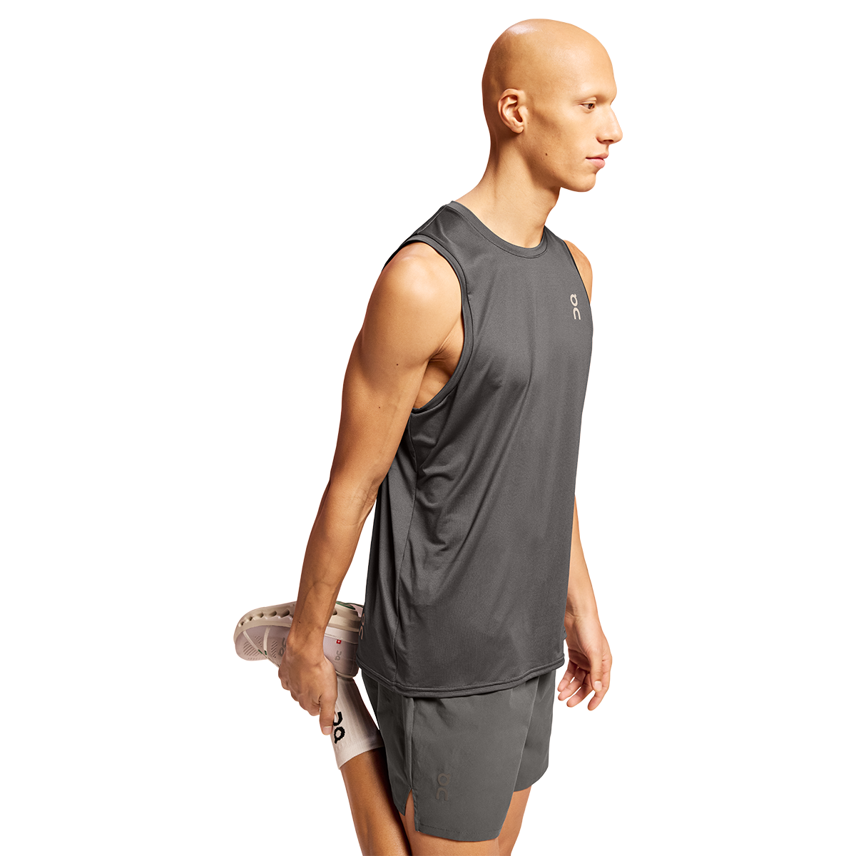 Man wearing dark gray On Core Tank sleeveless athletic shirt on white background