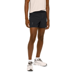 Man wearing black On 5-inch lightweight running shorts with pink tank top and white sneakers