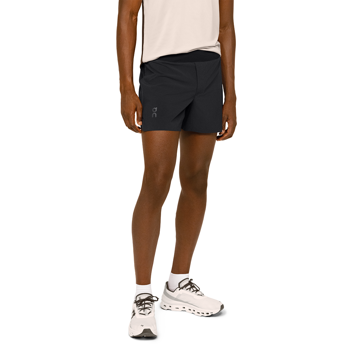 Man wearing black On 5-inch lightweight running shorts with pink tank top and white sneakers
