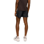 Man wearing black On 5-inch lightweight running shorts, back view on white background