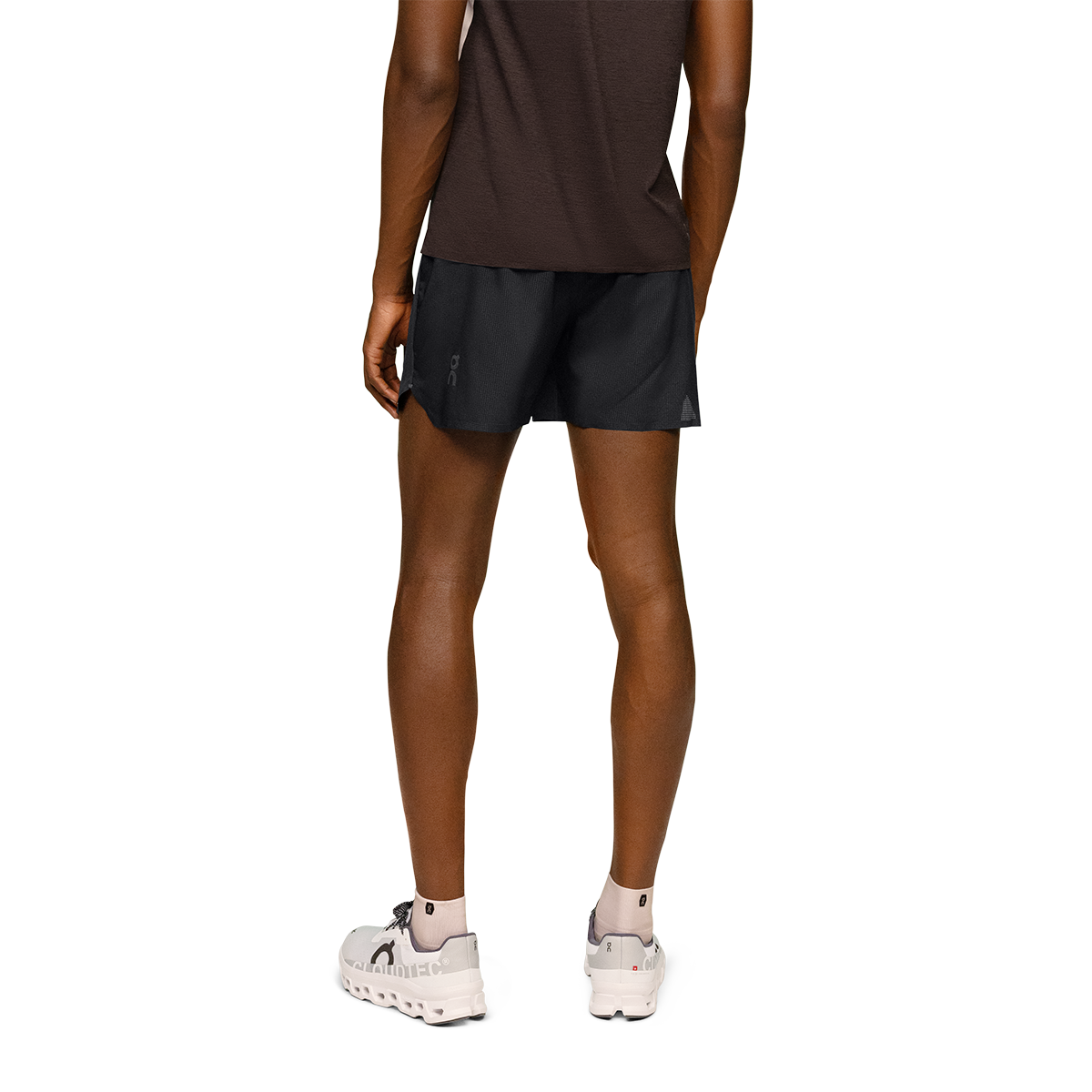 Man wearing black On 5-inch lightweight running shorts, back view on white background