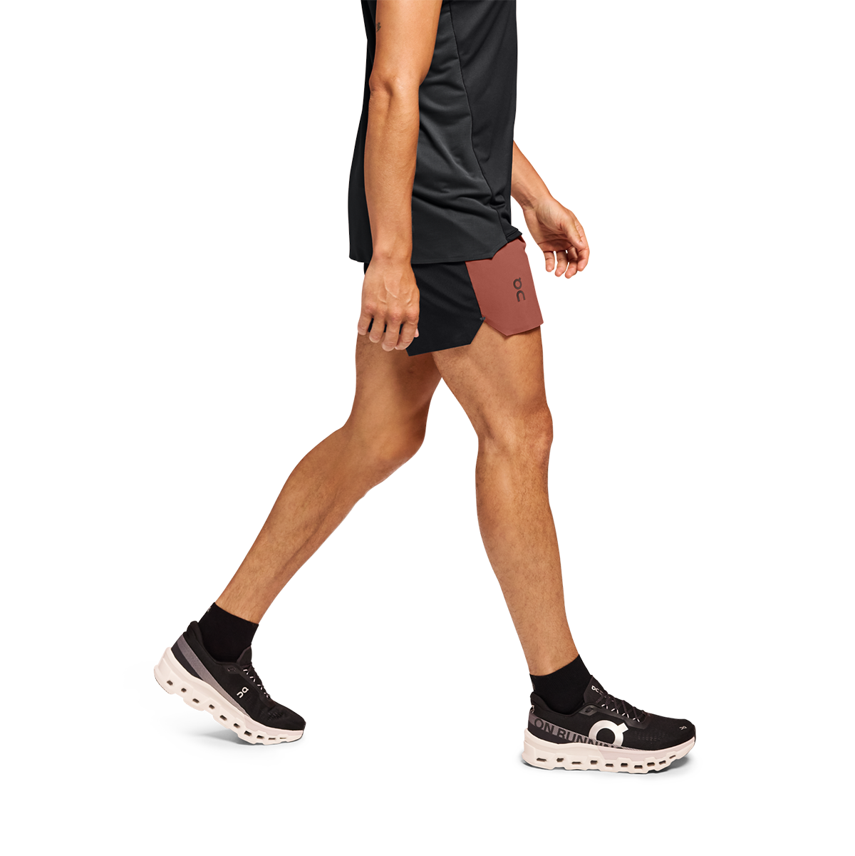 Man running in black On 5-inch lightweight shorts with rust accent panel
