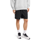 Man wearing black On Focus Shorts with gray sweatshirt and white running shoes