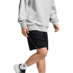 Man wearing black On Focus Shorts with grey sweatshirt and white sneakers
