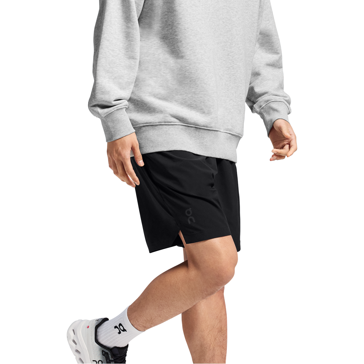 Man wearing black On Focus Shorts with grey sweatshirt and white sneakers