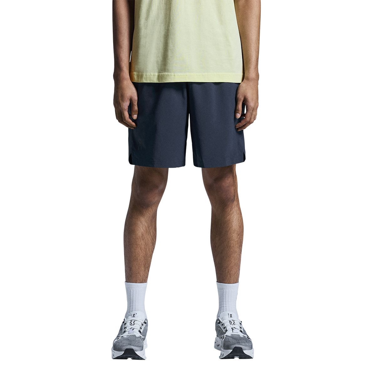 Man wearing On Focus Shorts in navy blue with light green shirt and running shoes
