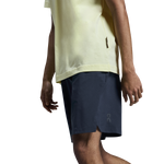 Man wearing On Focus Shorts in navy blue with yellow shirt on white background