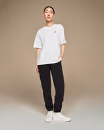 On Running Club-T white t-shirt full body view styled with black joggers and white sneakers