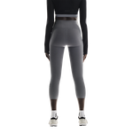 Woman wearing gray On Studio Tights 7/8 leggings from behind on white background