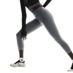 Woman wearing On Studio Tights 7/8 in light gray performing athletic movement