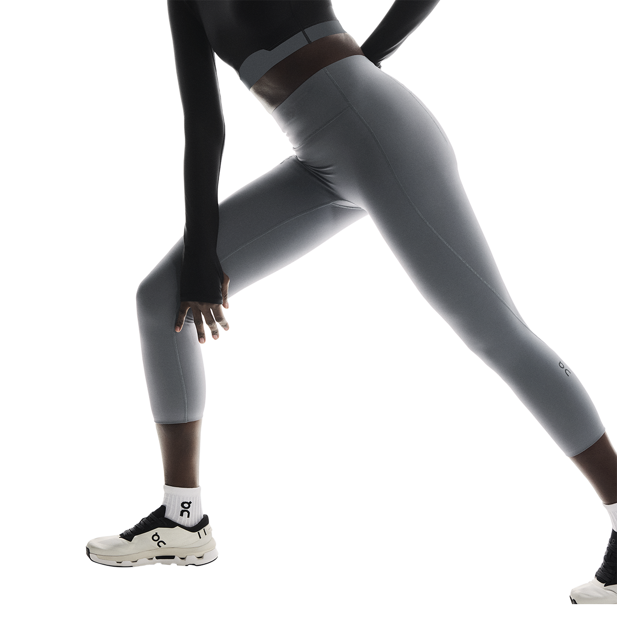 Woman wearing On Studio Tights 7/8 in light gray performing athletic movement