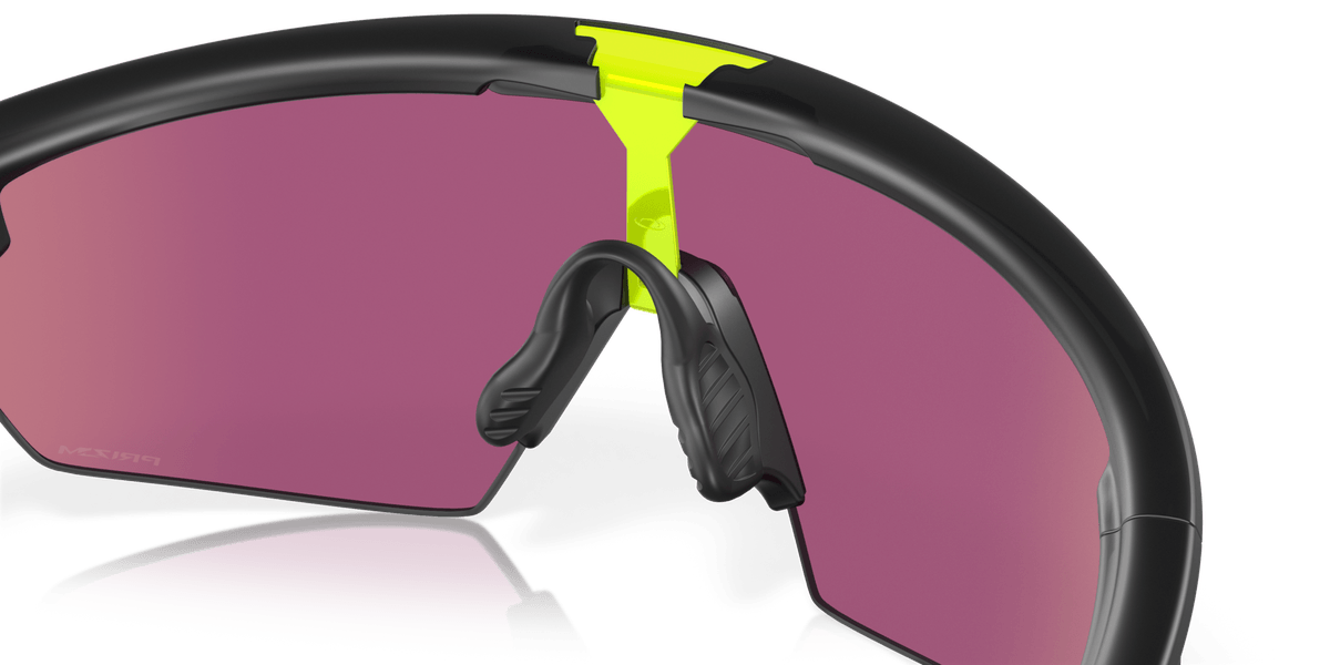 Oakley Sphaera sunglasses with matte black frame, yellow accents, and purple-pink lenses