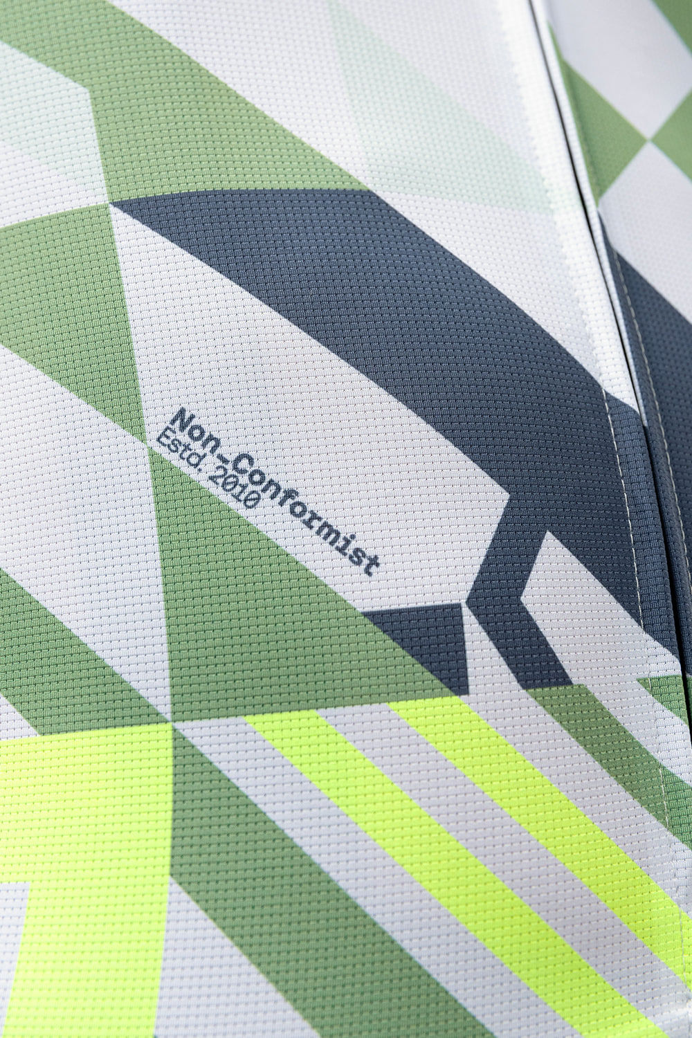 Gobik CX Pro cycling jersey close-up showing geometric fish pattern in green, white, and navy