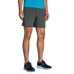 Man wearing Brooks Sherpa 7-inch running shorts in dark gray with blue shirt