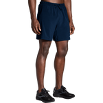 Man wearing navy blue Brooks Moment 7-inch running shorts with elastic waistband and drawstring