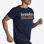 Man running wearing Brooks Distance Short Sleeve 2.0 in HTR Navy Brooks Track Stripe