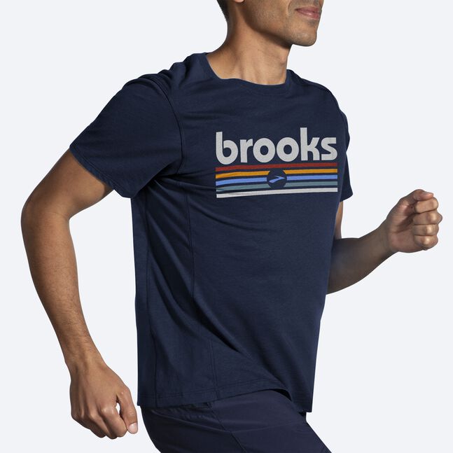 Man running wearing Brooks Distance Short Sleeve 2.0 in HTR Navy Brooks Track Stripe