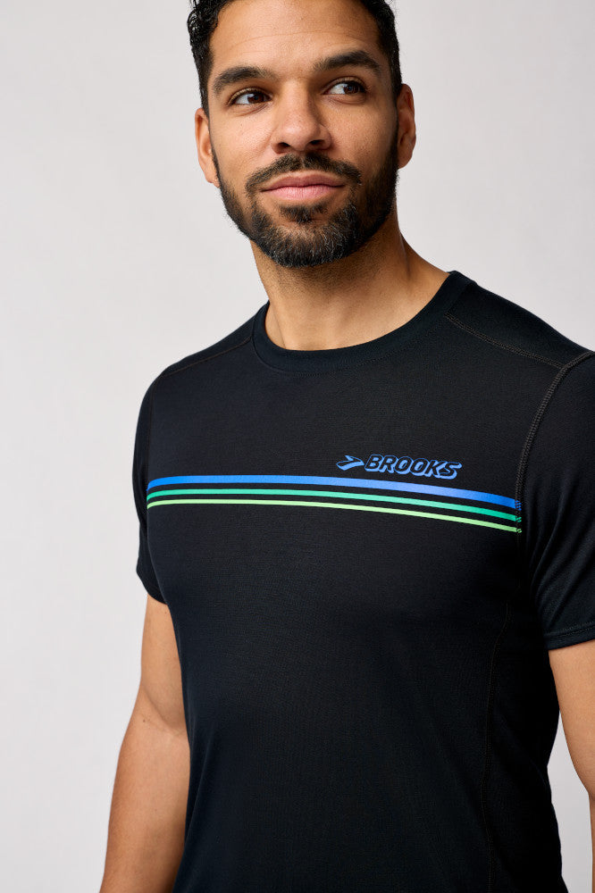 Man wearing Brooks Distance Short Sleeve 3.0 black running shirt with colorful chest stripes