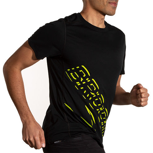 Man running in Brooks Distance Short Sleeve 3.0 black shirt with neon yellow graphic