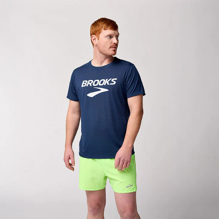 Man wearing Brooks Distance Short Sleeve 3.0 navy blue logo tee with lime green shorts