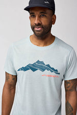 Man wearing Brooks Distance Short Sleeve 3.0 in light ash blue with mountain graphic