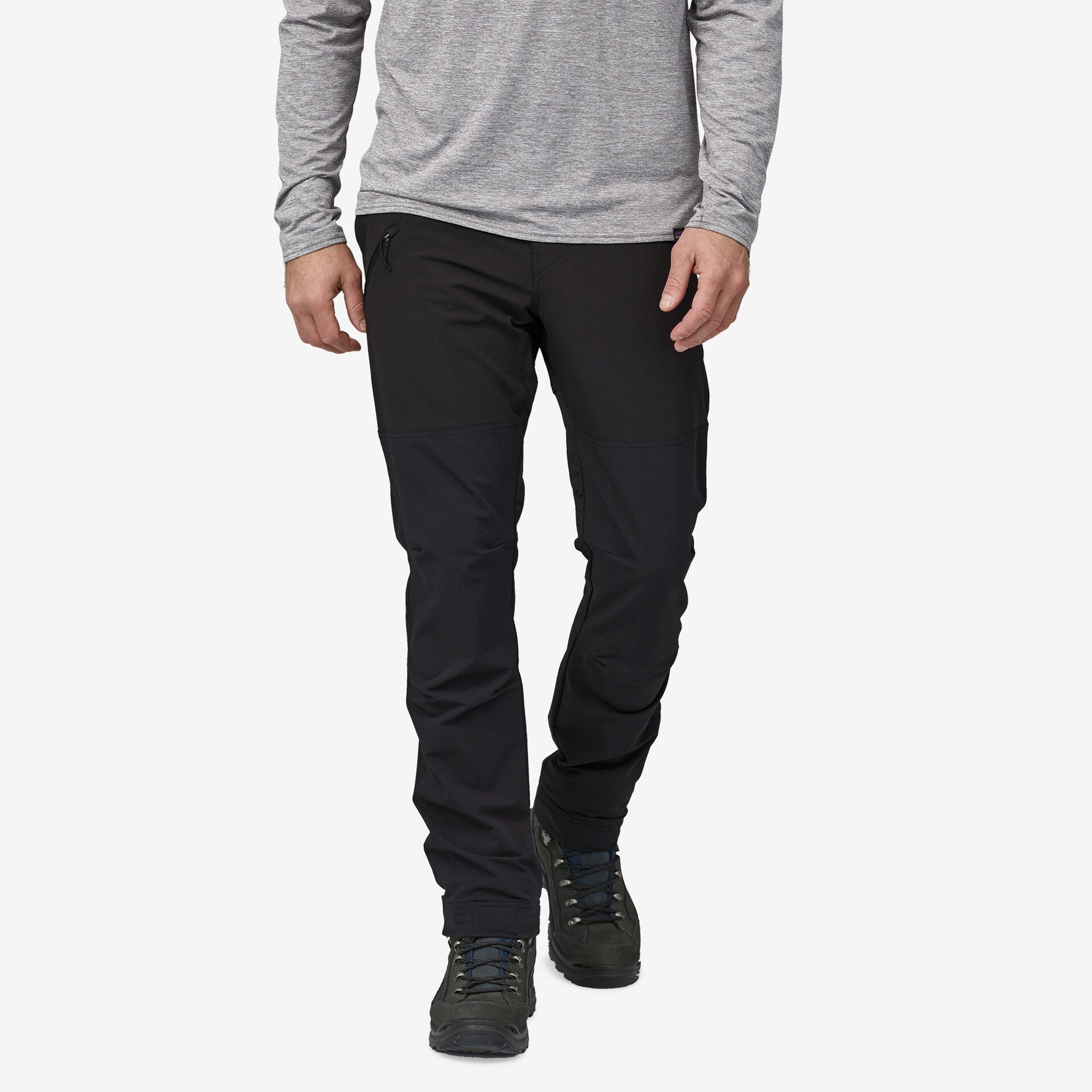Man wearing black Patagonia trail pants with gray long-sleeve shirt and hiking boots